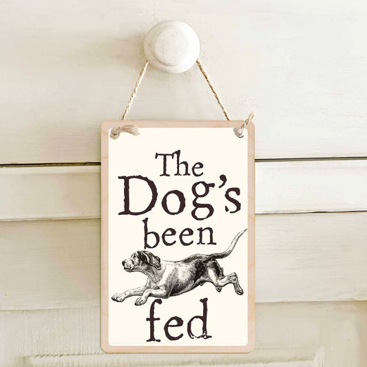 The Dog's been fed / The dog's not been fed - Double-sided wooden mini sign.

Made from certified sustainable wood and printed on both sides with a fun, practical message and retro illustration.

15 × 10 cm sustainable wood, natural twine.

Light and durable, eco-friendly, ready to hang.

Made in Suffolk