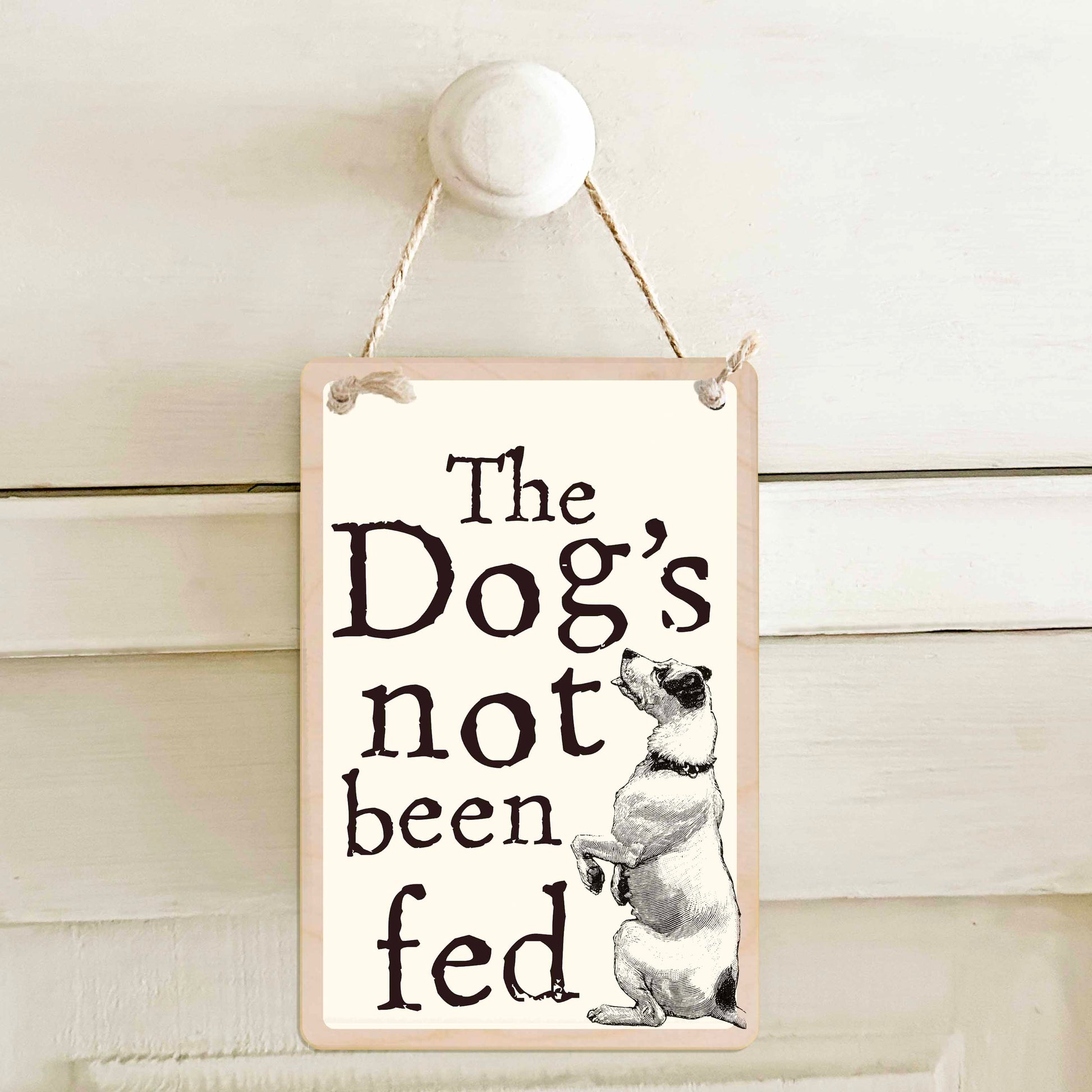 The Dog's not been fed / The dog's not been fed - Double-sided wooden mini sign.

Made from certified sustainable wood and printed on both sides with a fun, practical message and retro illustration.

15 × 10 cm sustainable wood, natural twine.

Light and durable, eco-friendly, ready to hang.

Made in Suffolk