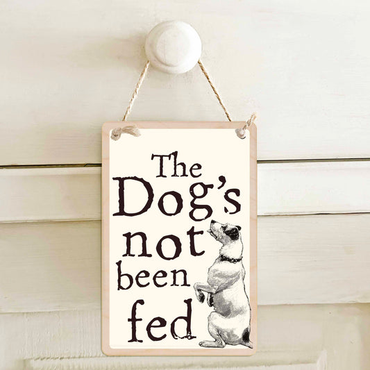 The Dog's not been fed / The dog's not been fed - Double-sided wooden mini sign.

Made from certified sustainable wood and printed on both sides with a fun, practical message and retro illustration.

15 × 10 cm sustainable wood, natural twine.

Light and durable, eco-friendly, ready to hang.

Made in Suffolk