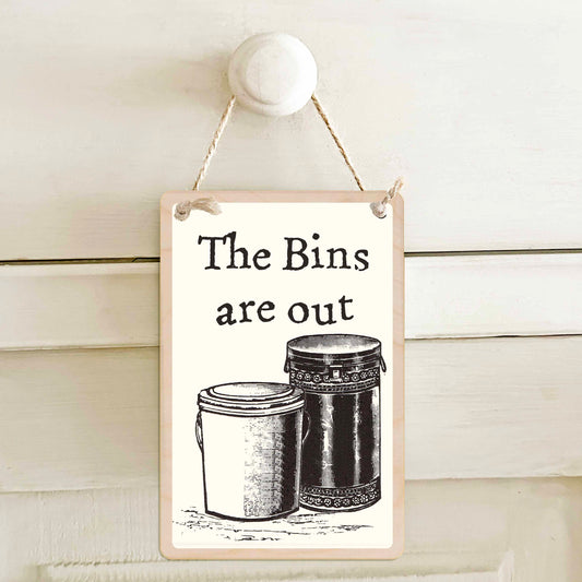 The bins are out / The bins need putting out - Double-sided wooden mini sign.

Made from certified sustainable wood and printed on both sides with a fun, practical message and retro illustration.

15 × 10 cm sustainable wood, natural twine.

Light and durable, eco-friendly, ready to hang.

Made in Suffolk.