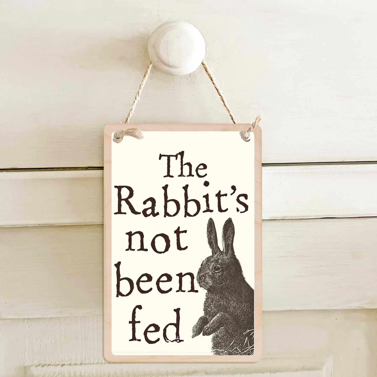 The Rabbit's been fed / The Rabbit's not been fed - Double-sided wooden mini sign.

Made from certified sustainable wood and printed on both sides with a fun, practical message and retro illustration.

15 × 10 cm sustainable wood, natural twine.
Light and durable, eco-friendly, ready to hang.

Made in Suffolk.