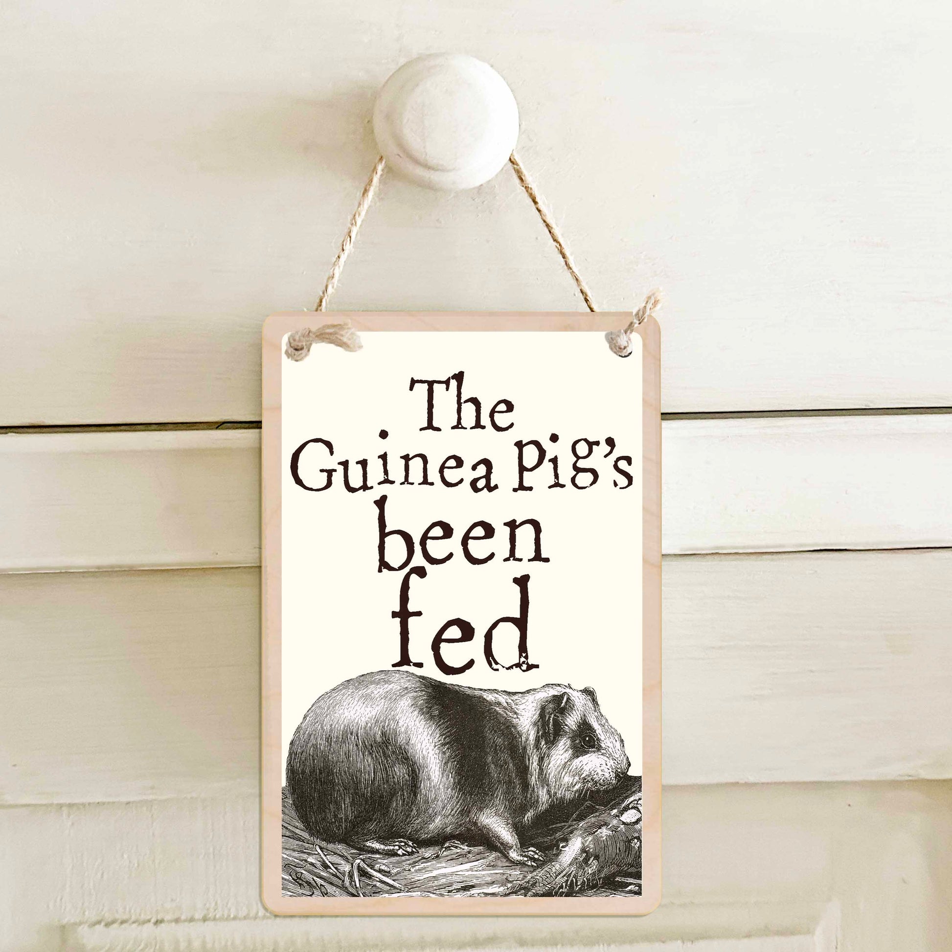Guinea Pig's been fed / The Guinea Pig's not been fed - Double-sided wooden mini sign.

Made from certified sustainable wood and printed on both sides with a fun, practical message and retro illustration.

15 × 10 cm sustainable wood, natural twine.

Light and durable, eco-friendly, ready to hang.

Made in Suffolk.