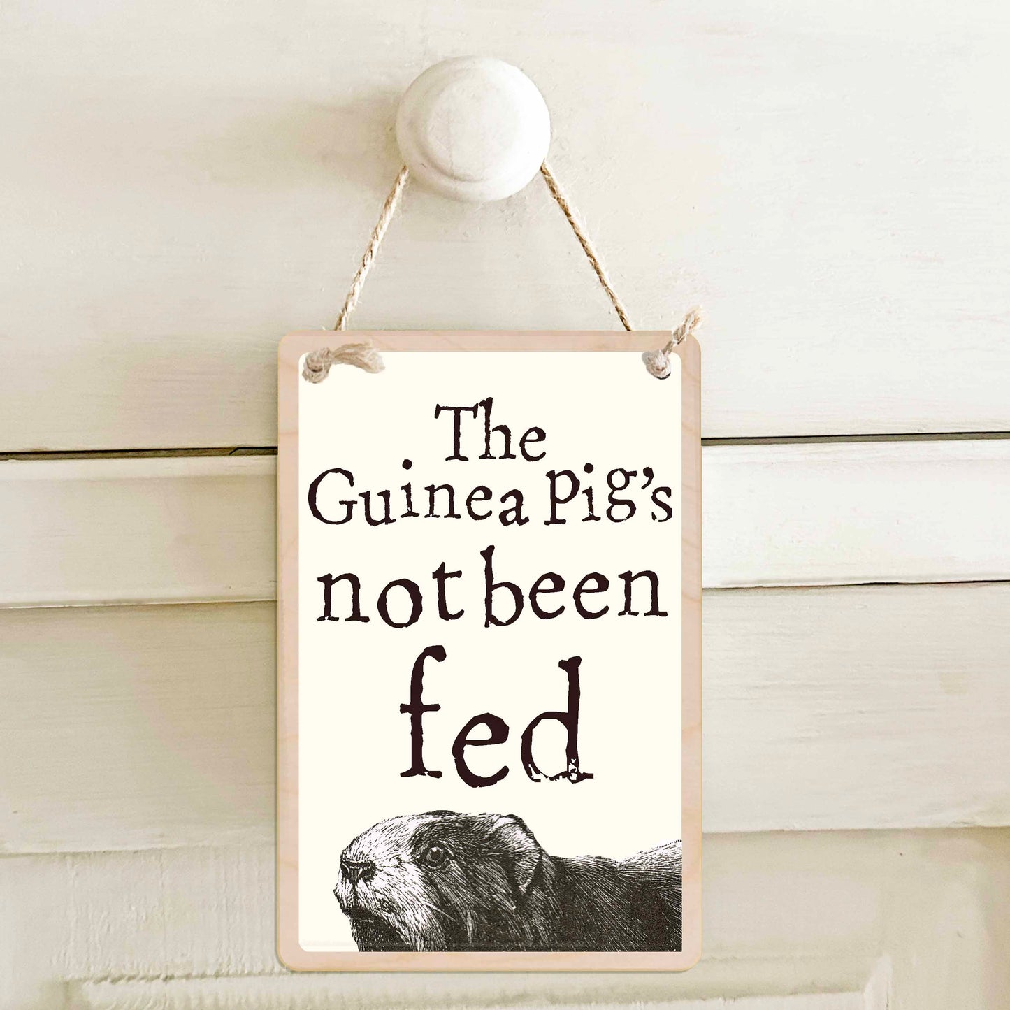 Guinea Pig's been fed / The Guinea Pig's not been fed - Double-sided wooden mini sign.

Made from certified sustainable wood and printed on both sides with a fun, practical message and retro illustration.

15 × 10 cm sustainable wood, natural twine.

Light and durable, eco-friendly, ready to hang.

Made in Suffolk.