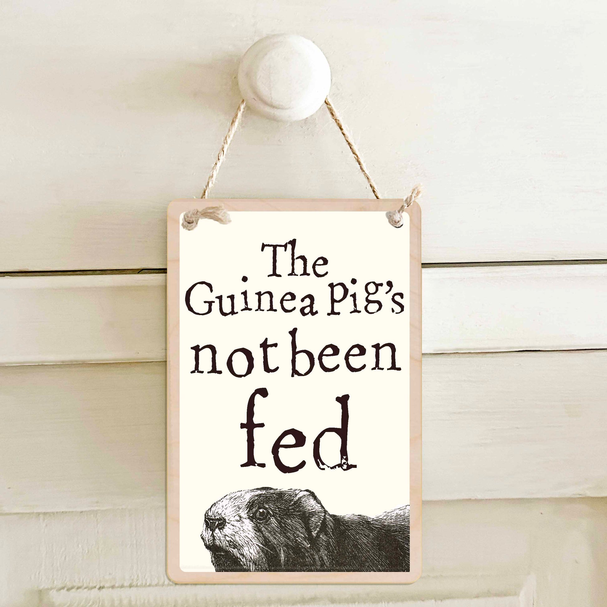 Guinea Pig's been fed / The Guinea Pig's not been fed - Double-sided wooden mini sign.

Made from certified sustainable wood and printed on both sides with a fun, practical message and retro illustration.

15 × 10 cm sustainable wood, natural twine.

Light and durable, eco-friendly, ready to hang.

Made in Suffolk.