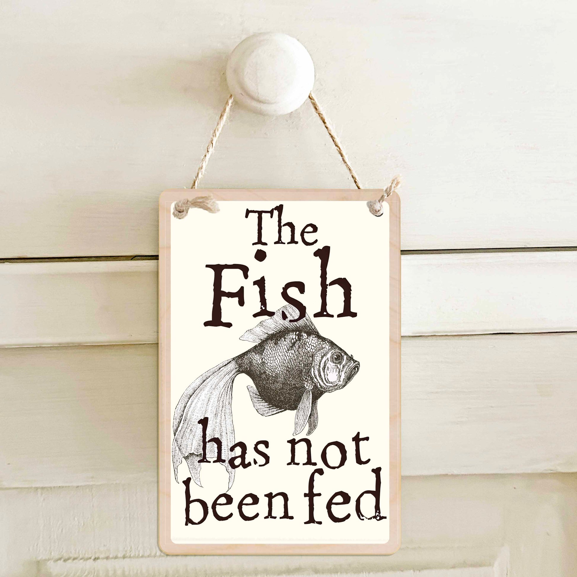 The fish has been fed / The fish has not been fed - Double-sided wooden mini sign.

Made from certified sustainable wood and printed on both sides with a fun, practical message and retro illustration.

15 × 10 cm sustainable wood, natural twine.&nbsp;

Light and durable, eco-friendly, ready to hang.

Made in Suffolk.