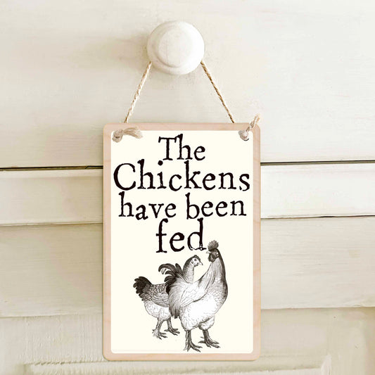 The chickens have been fed / The chickens have not been fed - Double-sided wooden mini sign.

Made from certified sustainable wood and printed on both sides with a fun, practical message and retro illustration.

15 × 10 cm sustainable wood, natural twine.&nbsp;

Light and durable, eco-friendly, ready to hang.

Made in Suffolk.