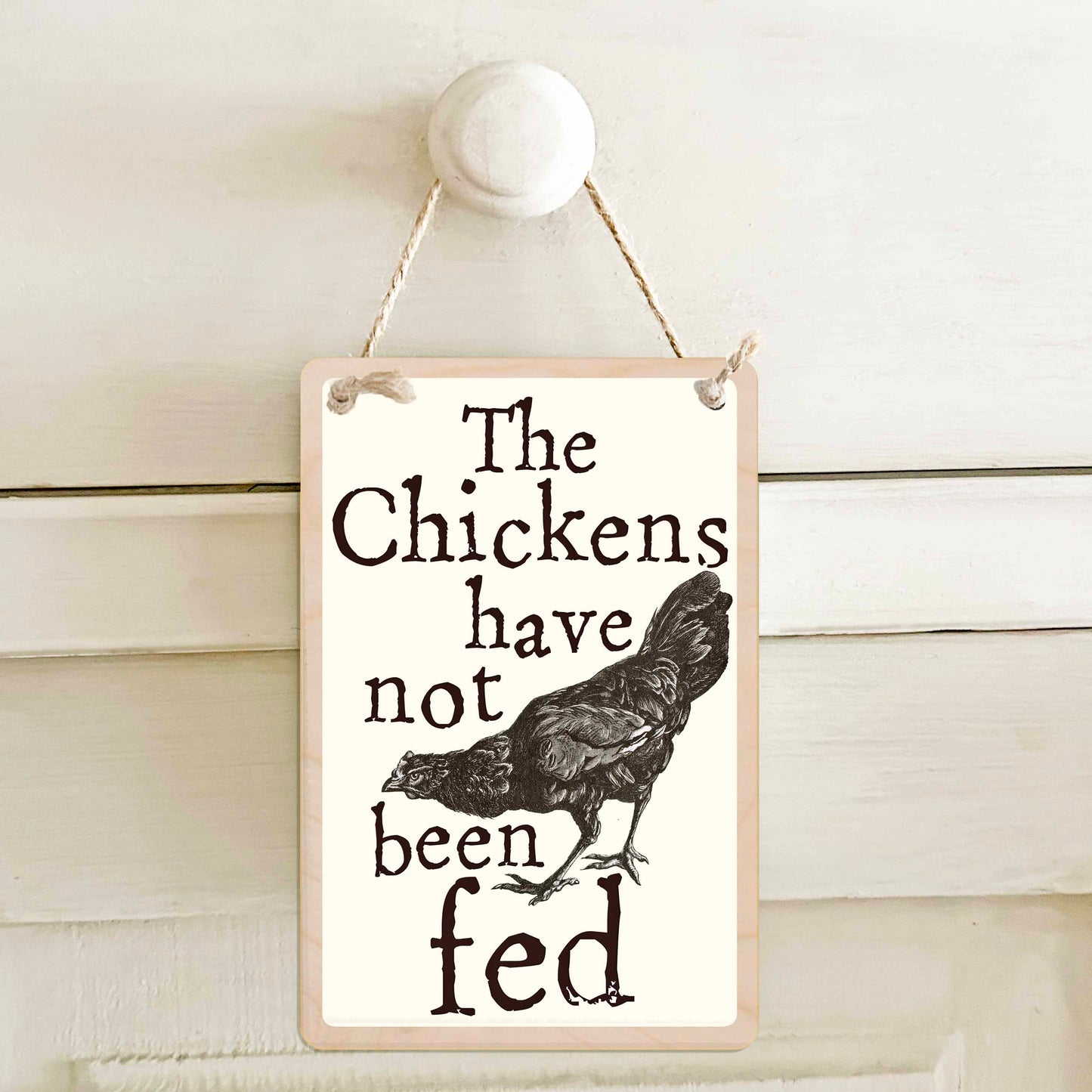 The chickens have been fed / The chickens have not been fed - Double-sided wooden mini sign.

Made from certified sustainable wood and printed on both sides with a fun, practical message and retro illustration.

15 × 10 cm sustainable wood, natural twine.&nbsp;

Light and durable, eco-friendly, ready to hang.

Made in Suffolk.