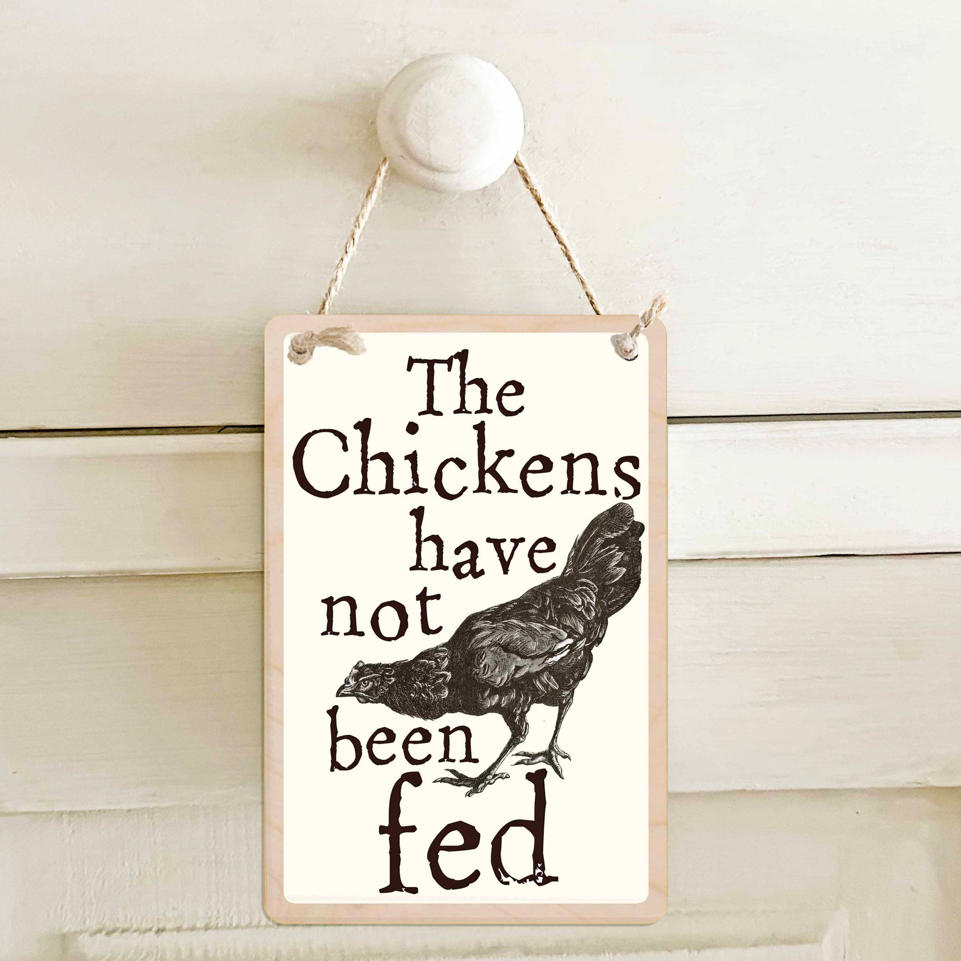 The chickens have been fed / The chickens have not been fed - Double-sided wooden mini sign.

Made from certified sustainable wood and printed on both sides with a fun, practical message and retro illustration.

15 × 10 cm sustainable wood, natural twine.&nbsp;

Light and durable, eco-friendly, ready to hang.

Made in Suffolk.