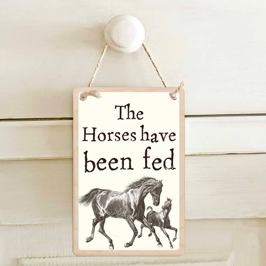 The horses have been fed / The horses have not been fed - Double-sided wooden mini sign.

Made from certified sustainable wood and printed on both sides with a fun, practical message and retro illustration.

15 × 10 cm sustainable wood, natural twine.

Light and durable, eco-friendly, ready to hang.

Made in Suffolk.&nbsp;