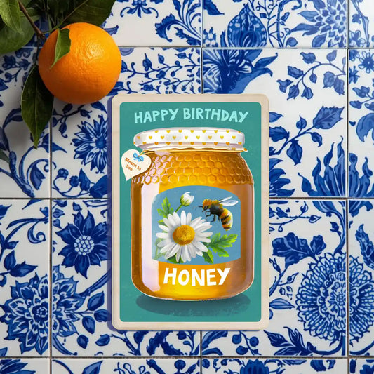 Birthday card:Honey jar with a bee and daisy on a blue background,  'Happy Anniversary Honey'. Wooden Postcard Company